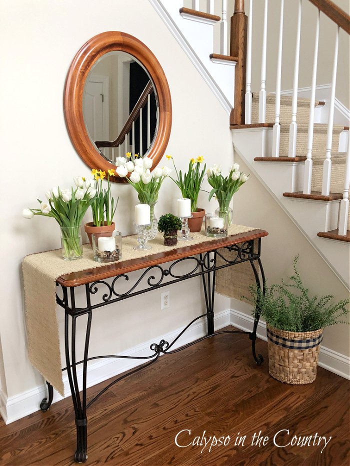 flowers and plants on foyer table - ways to decorate with fake plants