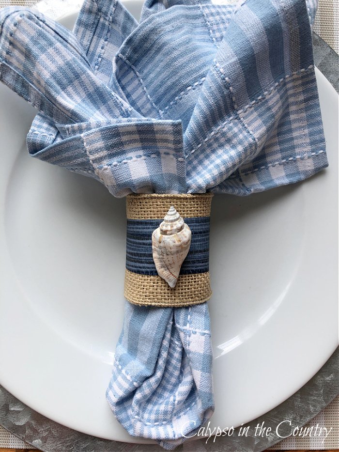 blue napkin with sea shell napkin ring - coastal table setting ideas