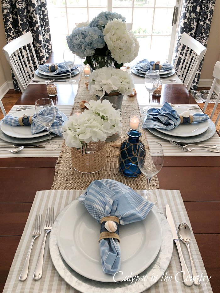 dining table decorated with blue and white accessories - coastal table setting ideas