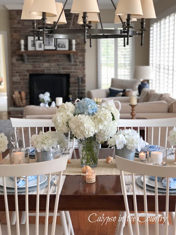 coastal table setting on wood table with white chairs