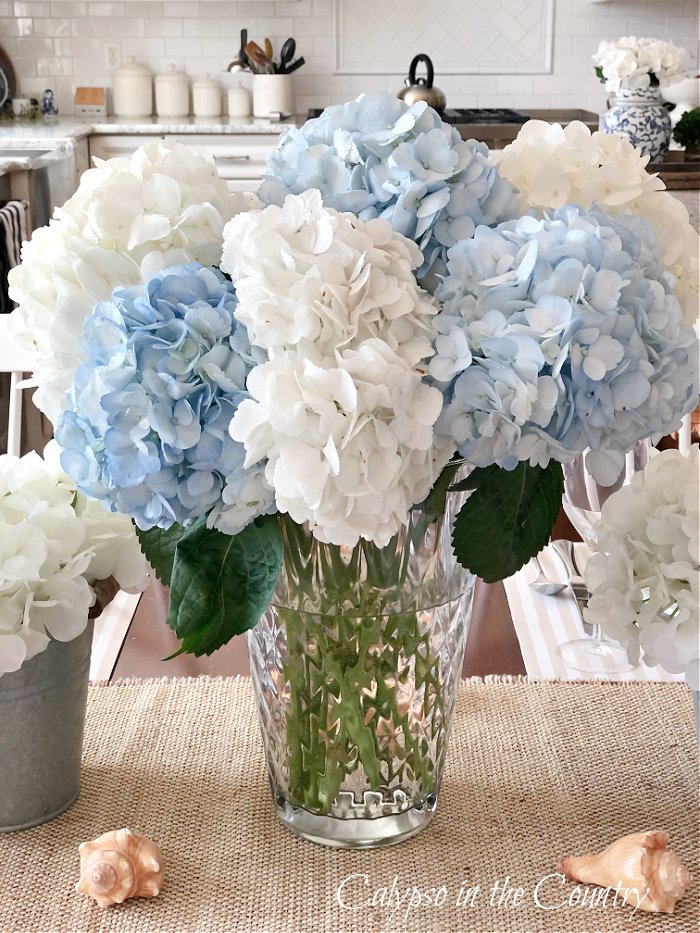 blue and white hydrangeas in glass vase - coastal centerpiece