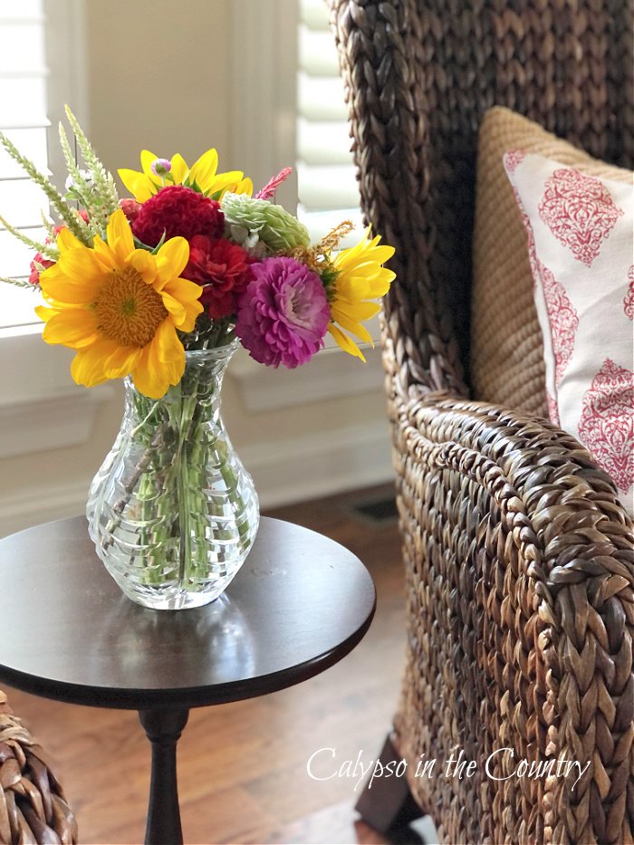 Sunflower bouquet in crystal vase on small table