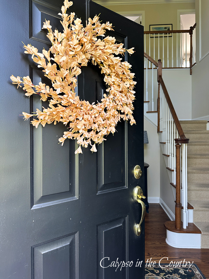 Neutral wreath on black front door - decorating your porch for fall