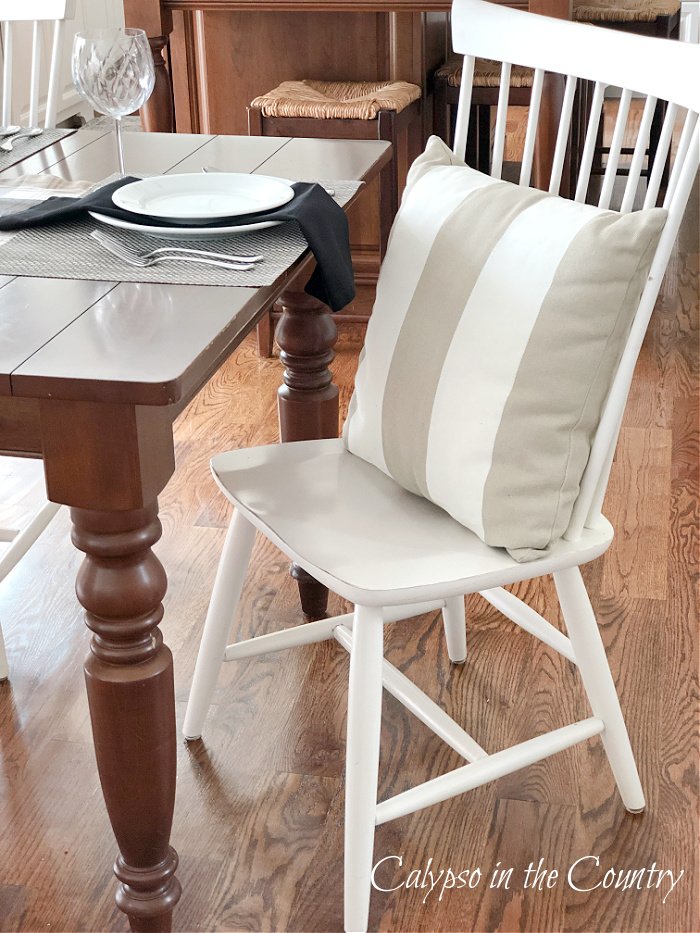 Tan and white striped pillow on white kitchen chair - neutral fall decor ideas