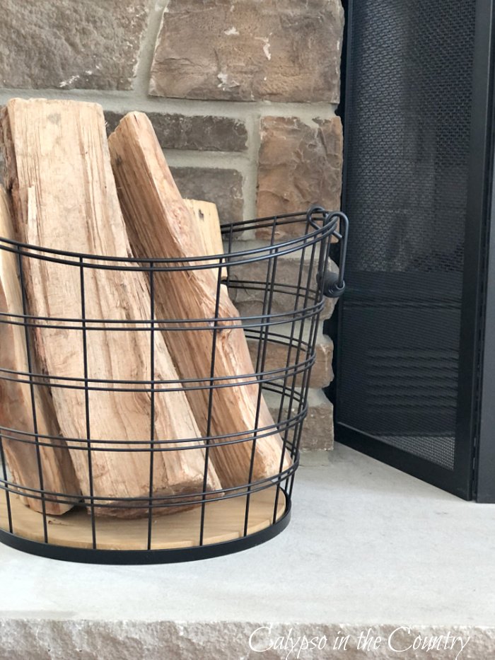 Black wire basket of firewood - neutral fall decor