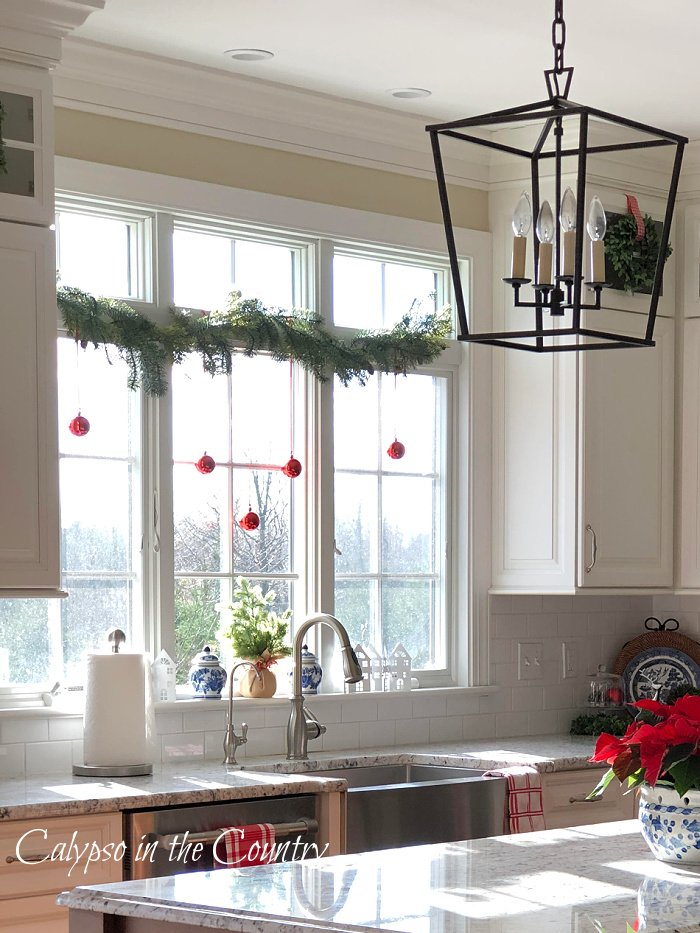 kitchen window over sink ideas for Christmas - garland and red ornaments