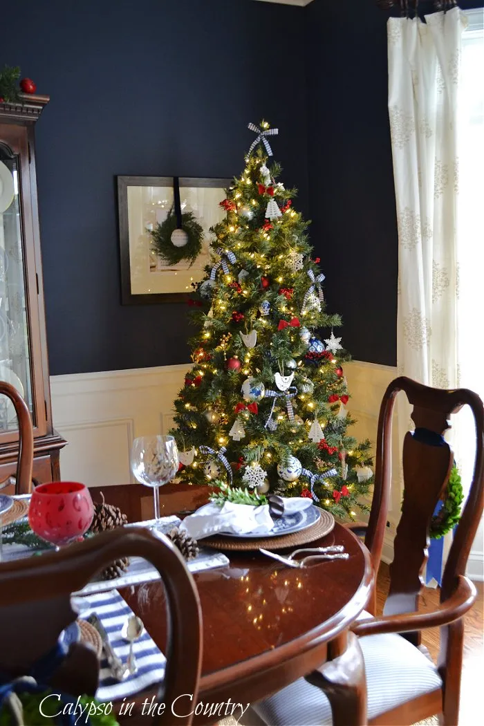 Navy dining room with Christmas tree in corner - blue Christmas tree decorating ideas