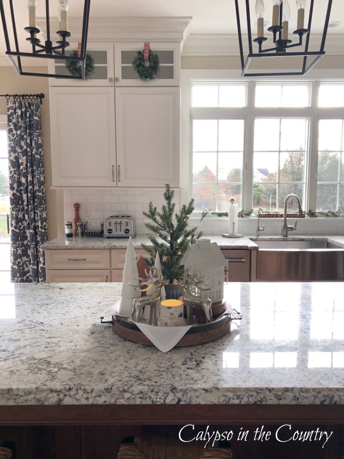 winter white decorations on round tray on kitchen island