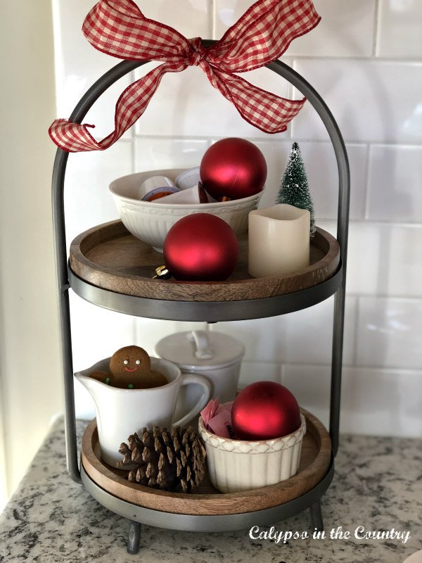 Red Christmas ornaments on tiered tray - enjoy the holiday season