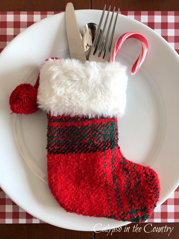 Red stocking utensil holder on white plate - Christmas stocking display ideas