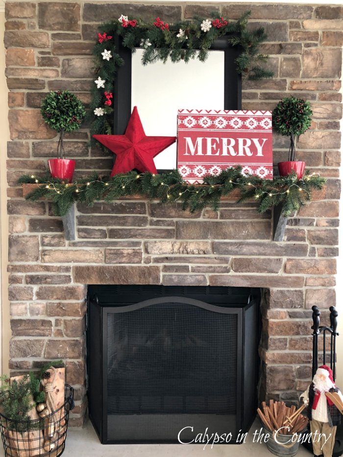 Stone fireplace decorated for Christmas with red and green 