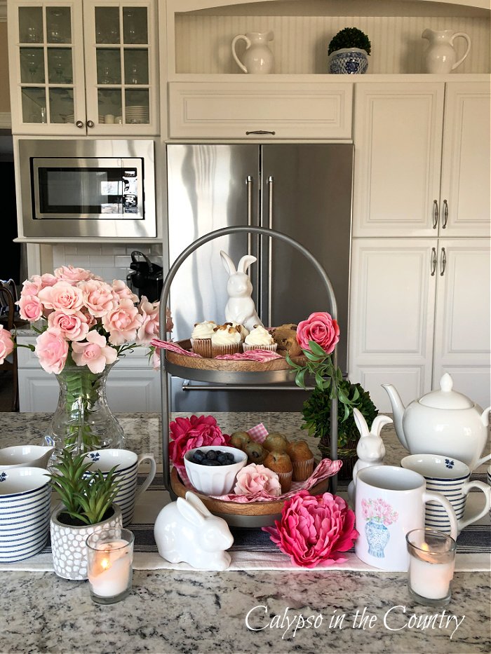 Flowers and tea party food on a wooden two tiered tray - how to decorate a tiered tray for tea time