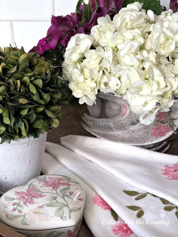 Vintage Valentines day decor with napkins and flowers in a silver bowl