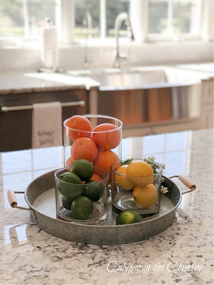 oranges, lemons and limes in glass containers - kitchen island centerpiece ideas