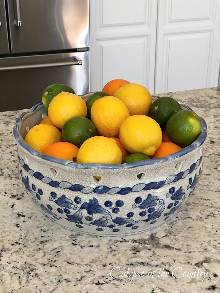 Lemons, limes and oranges in blue and white bowl - kitchen island decorating ideas