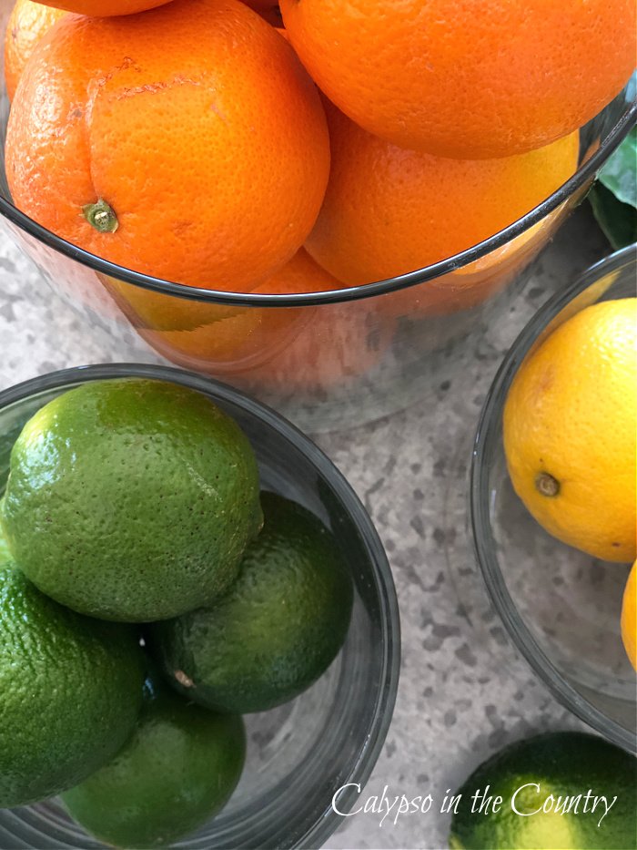 oranges, lemons and limes in glass containers - kitchen island decorating ideas 