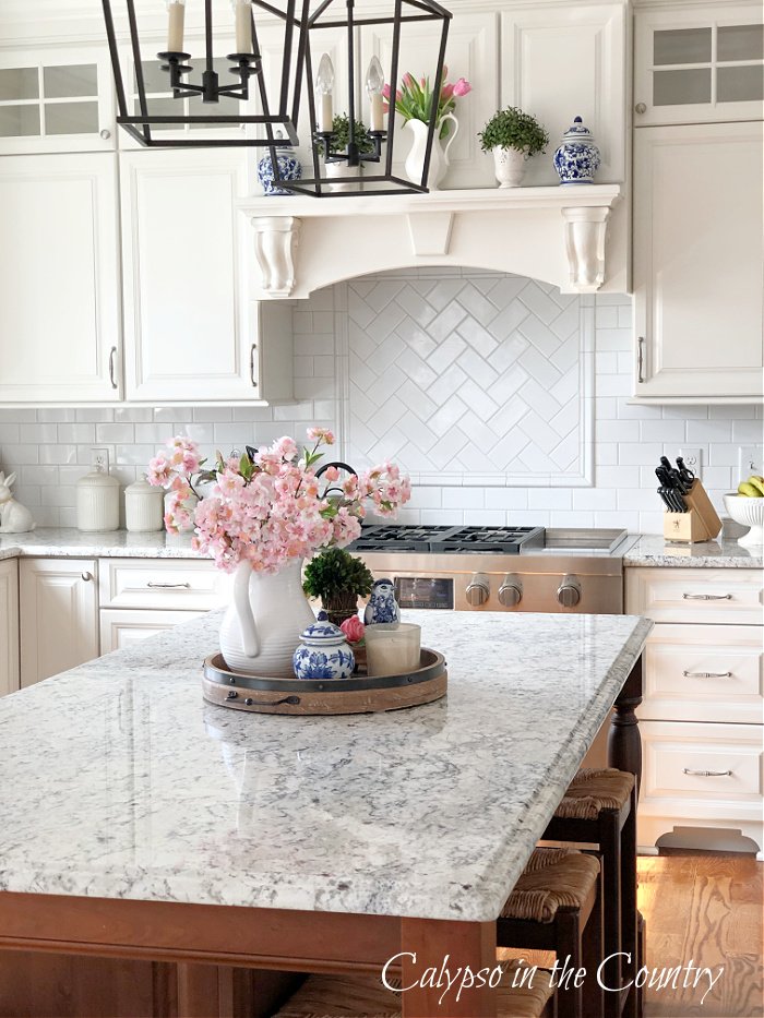 White kitchen with pink flowers on the island - spring decorating ideas