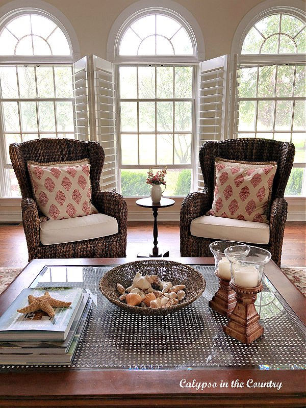 Block print pillows on seagrass chairs in front of windows