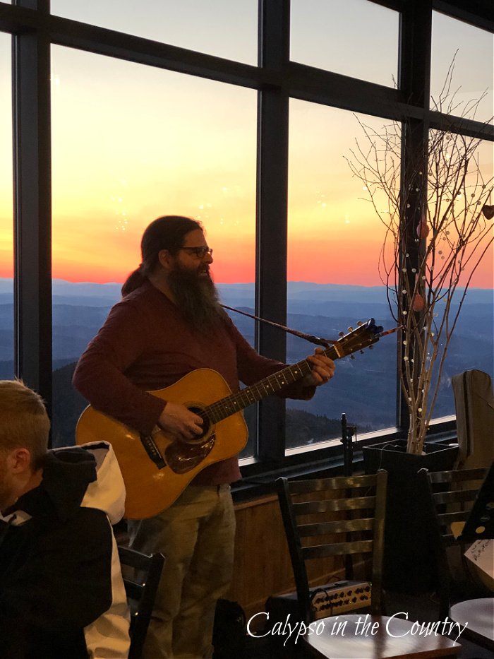 Guitar player in front of window with sun rising - April highlights