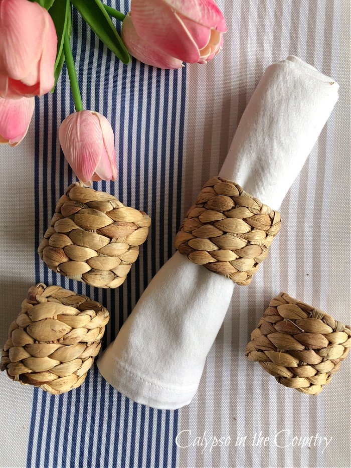 Seagrass napkin rings on striped tablecloth with pink tulips - April highlights