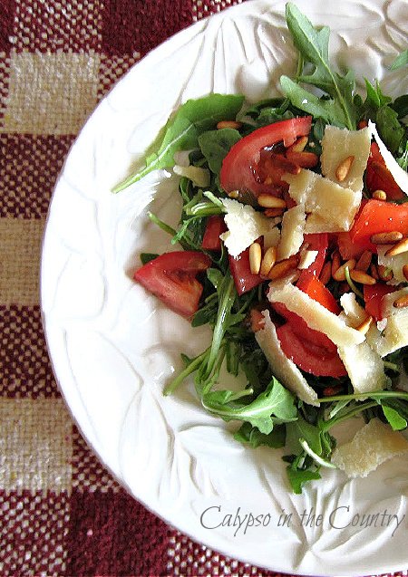 Arugula salad with parmesan and tomatoes in white dish - backyard picnic ideas