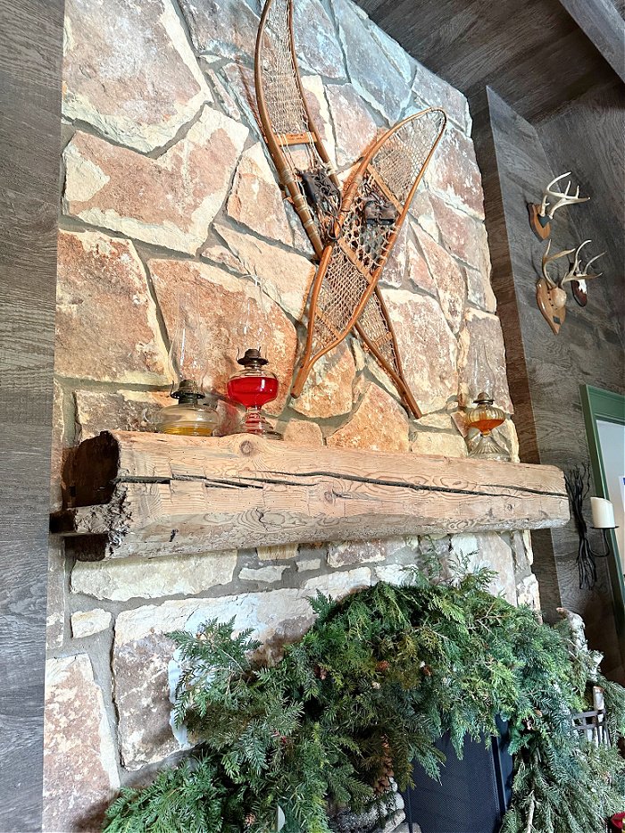 Rustic stone fireplace with snow shoes and greenery - Christmas decorating ideas