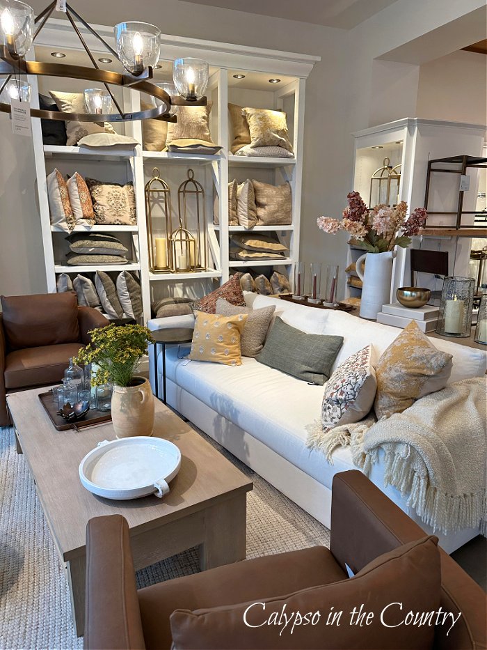 White sofa and brown chairs with fall pillows at Pottery Barn store - late summer decorating ideas