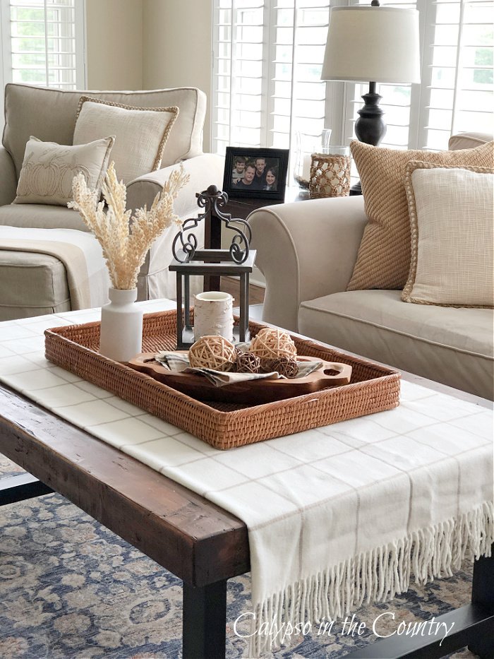 coffee table with rattan tray and neutral throw blanket - fall decor ideas 