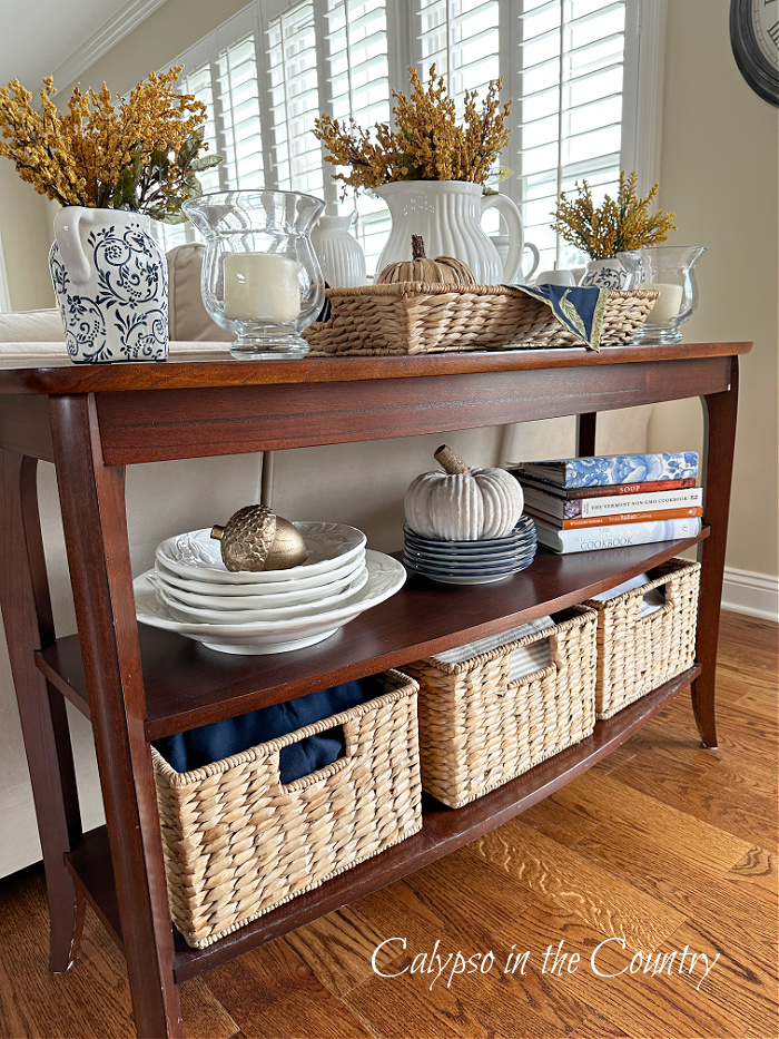 Wood console table with baskets and white pitchers - fall aesthetic ideas