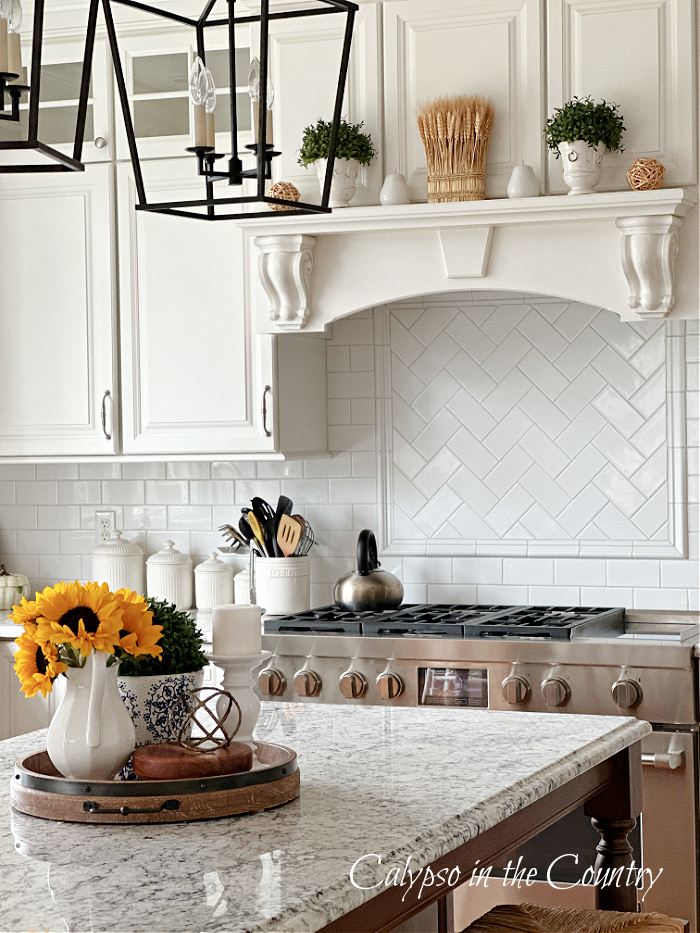 White kitchen decorated for fall with wheat and sunflowers - simple fall aesthetic