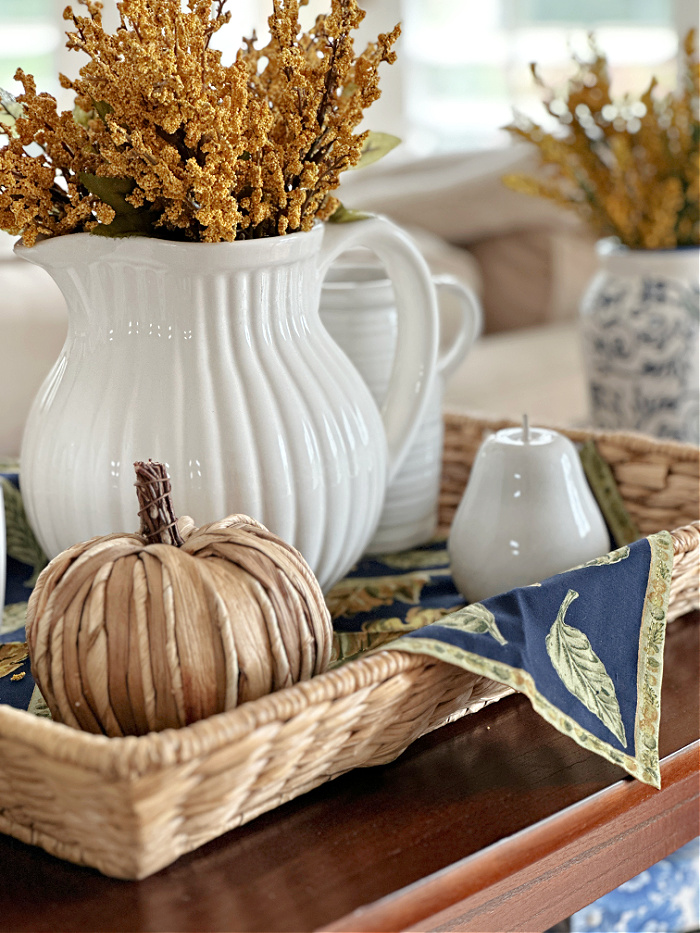White pitchers and fall decor on seagrass tray - fall aesthetic ideas