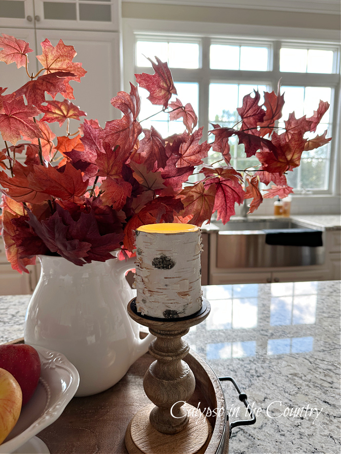 Red fall leaves in white pitcher on kitchen island - fall tray ideas