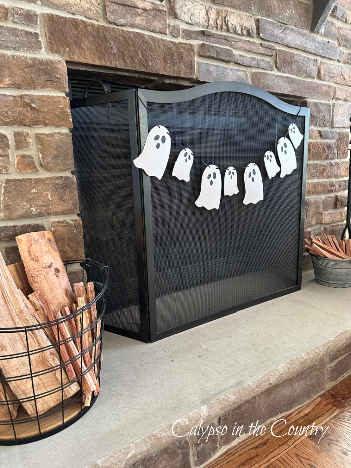 Halloween ghost garland hung on black fireplace screen