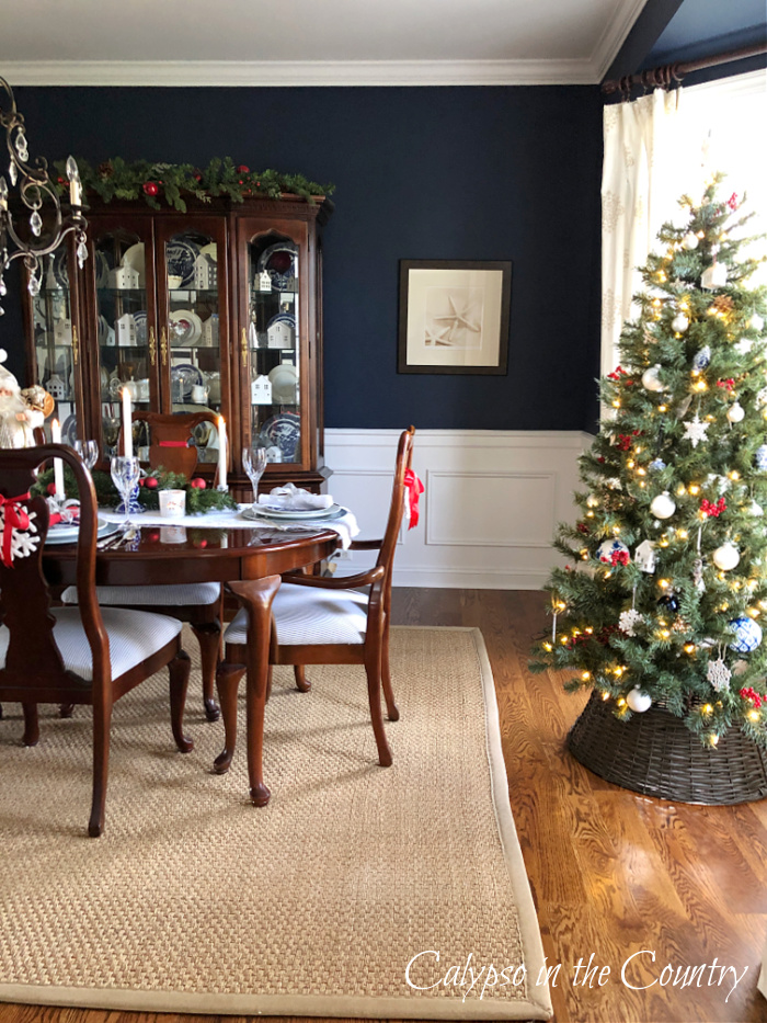 Navy blue dining room decorated for Christmas with tree in window - goodbye November hello December