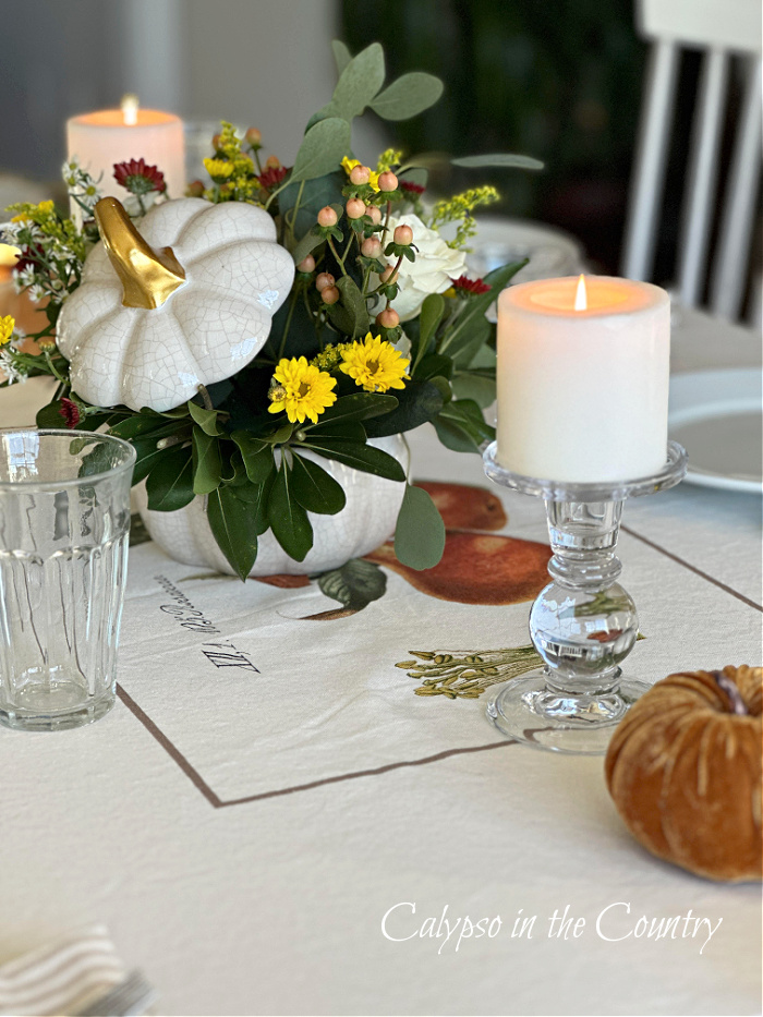 White pumpkin floral centerpiece and candles on Thanksgiving table - goodbye November hello December