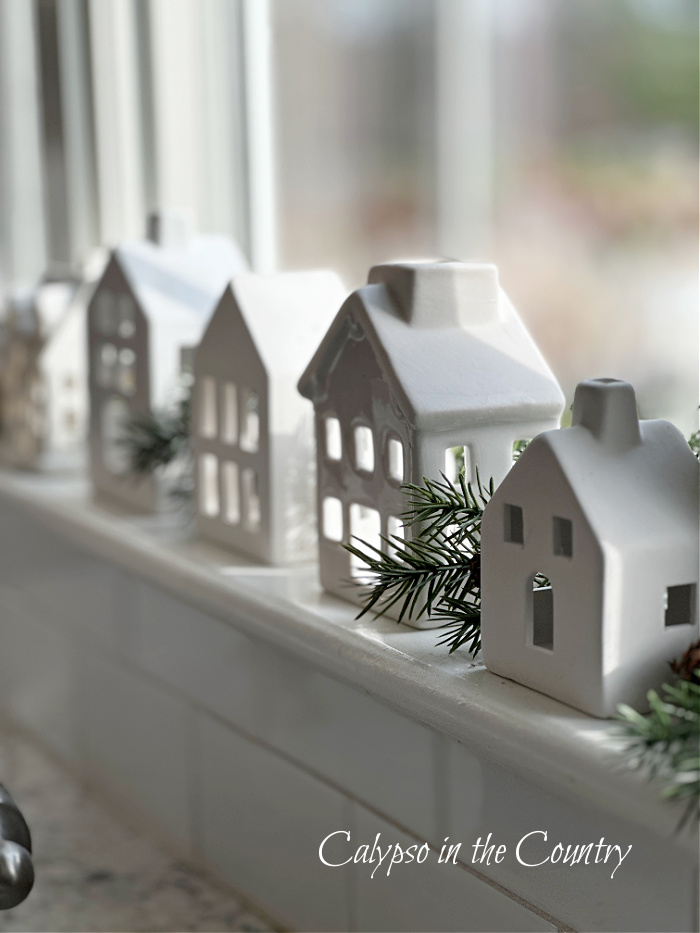White ceramic houses on windowsill