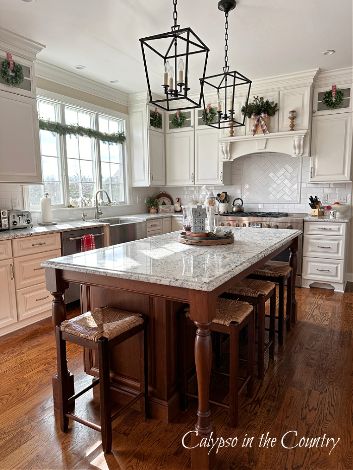 White kitchen with wood floors and stained island decorated for Christmas - cozy Christmas home tour