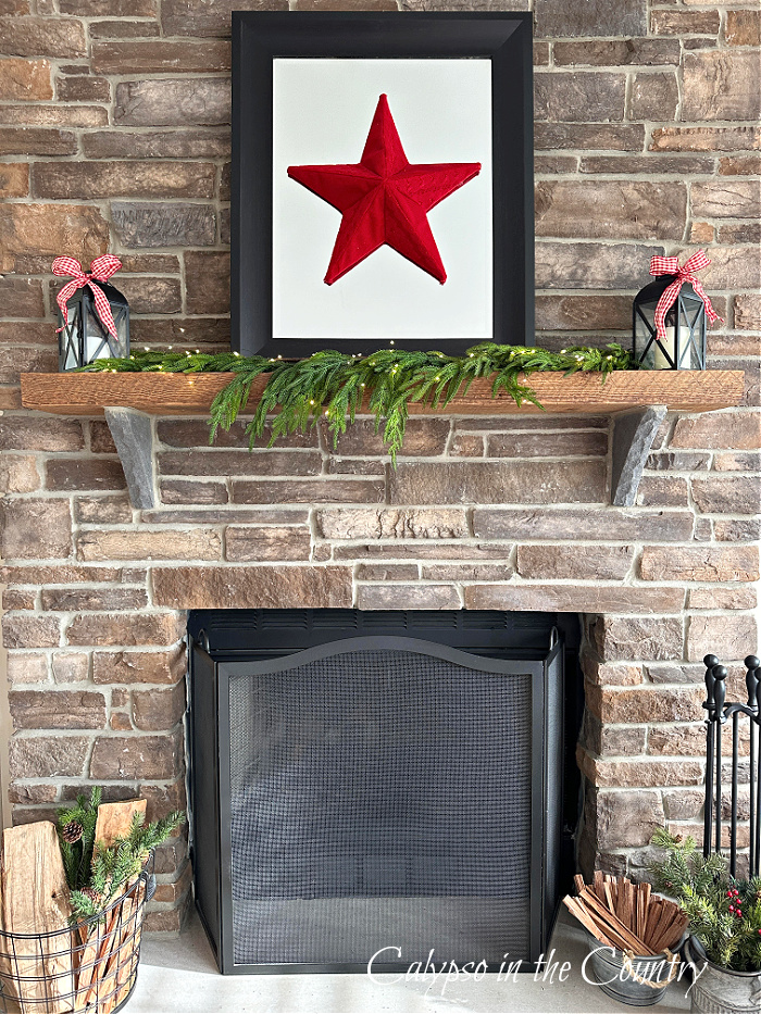 Stone fireplace decorated with black mirror and red star - cozy Christmas home tour