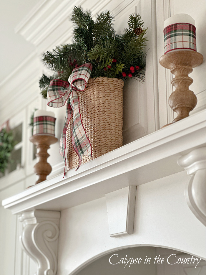 White stove mantel decorated with basket of greenery