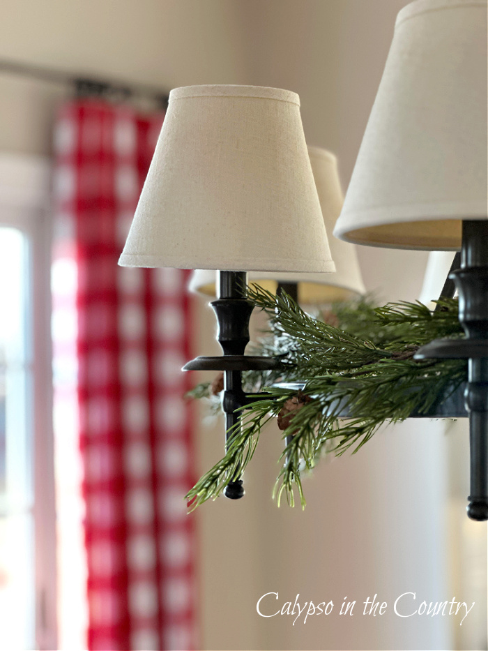 Red checked curtains and chandelier with greenery - cozy Christmas home tour