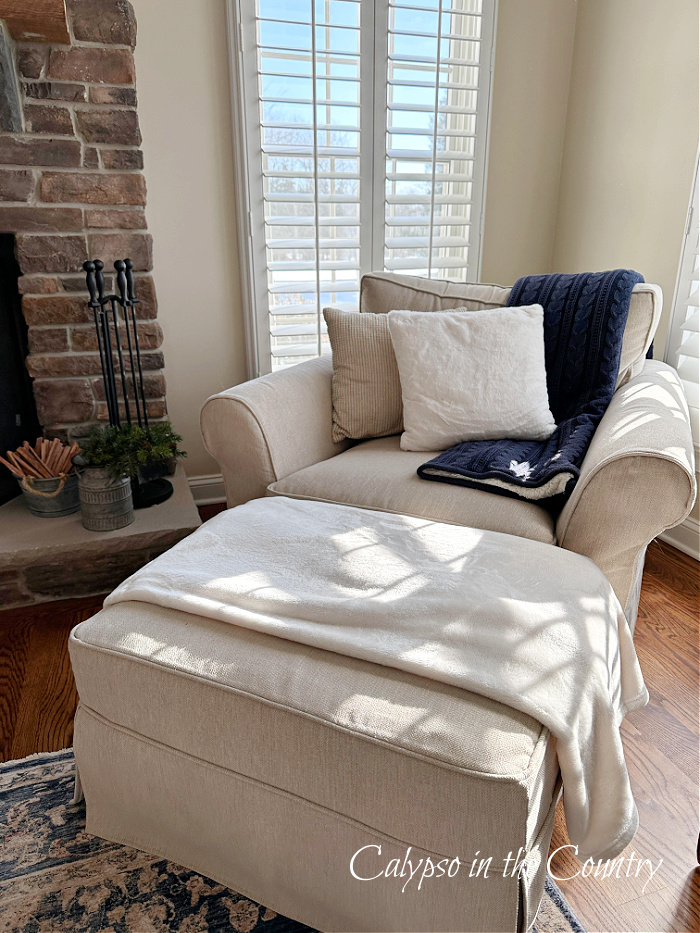Chair and ottoman with plush blankets and pillows - January decorating inspiration