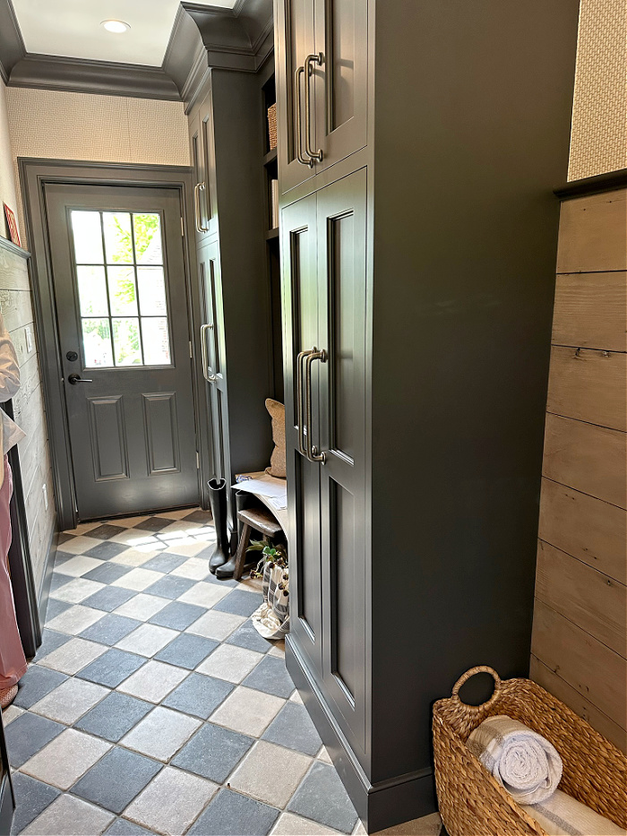 Mudroom with checkerboard floor and gray storage cabinets in designer showhouse