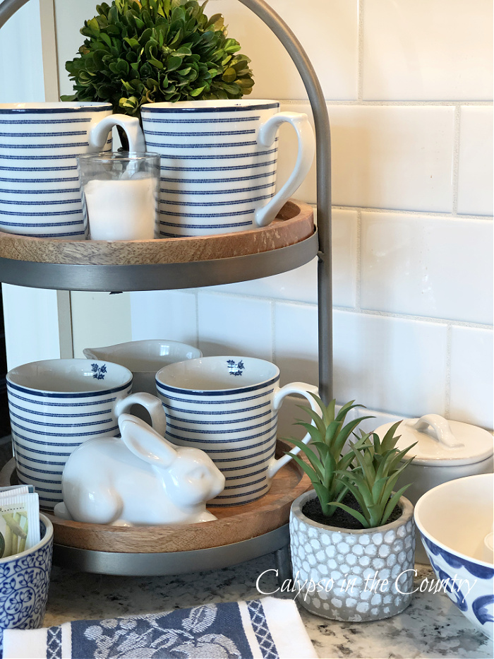 Wood and metal tiered tray decorated with blue striped mugs and plants - favorites of 2023.