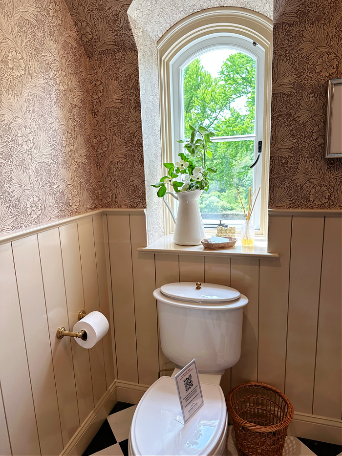 Arched window over toilet in traditional bathroom