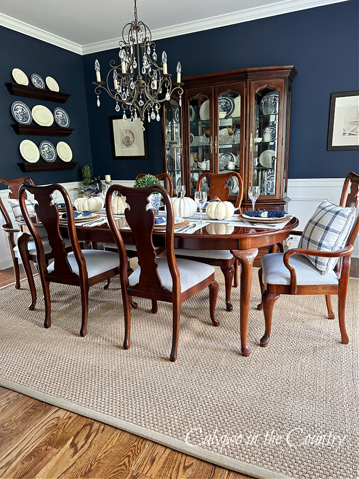 Navy blue dining room with traditional wood furniture and seagrass rug