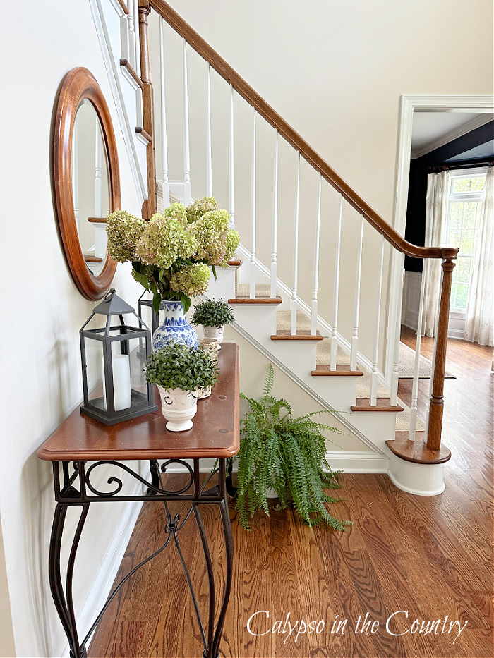 Staircase and foyer table decorated for fall with blue and white 
