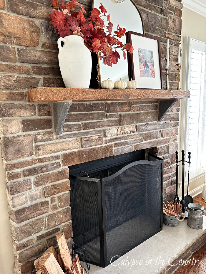Stone fireplace with rustic wood mantel decorated for fall - simple elegant fall decor
