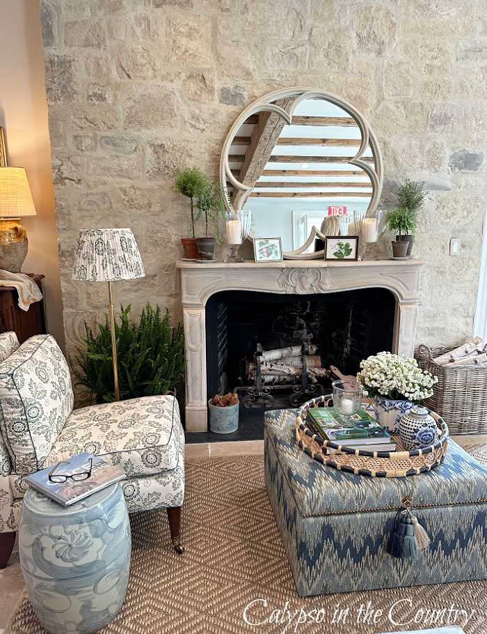 Stone fireplace wall with blue and white patterned furniture and lamp