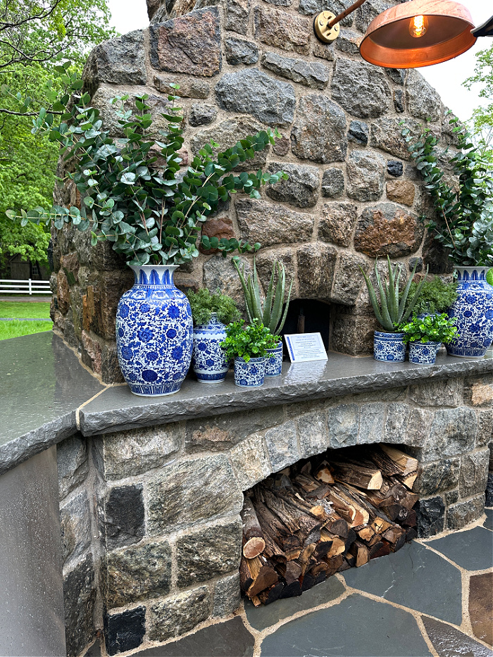 Outdoor stone fireplace with blue and white vases - patio season