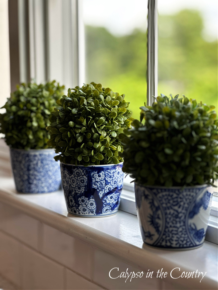 boxwood spheres in blue and white porcelain on kitchen windowsill - june recap